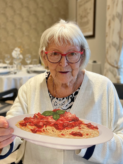 resident holding a picture of spaghetti