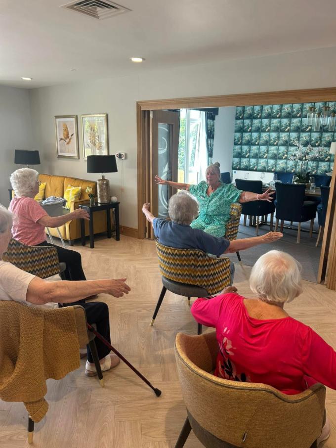 older people doing seated exercise in Sandmere care home