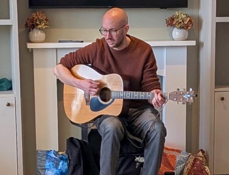 entertainer singing in care home with guitar