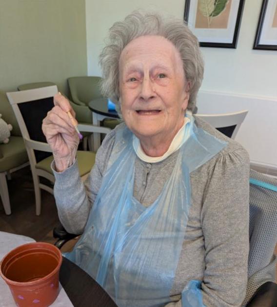 resident smiling with potting plants and decorating them