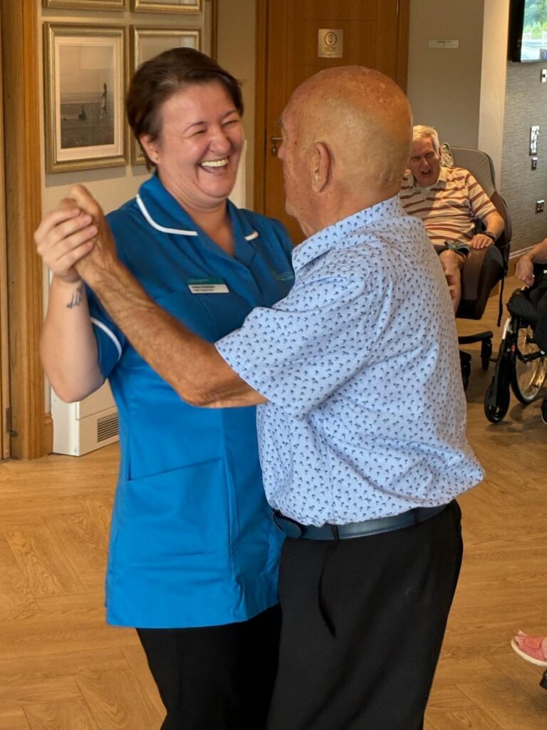 resident and carer dancing at Sandmere care home