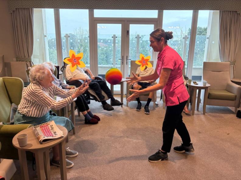 resident with care worker playing with a ball
