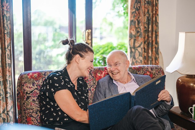 resident looking at pictures with family visitor