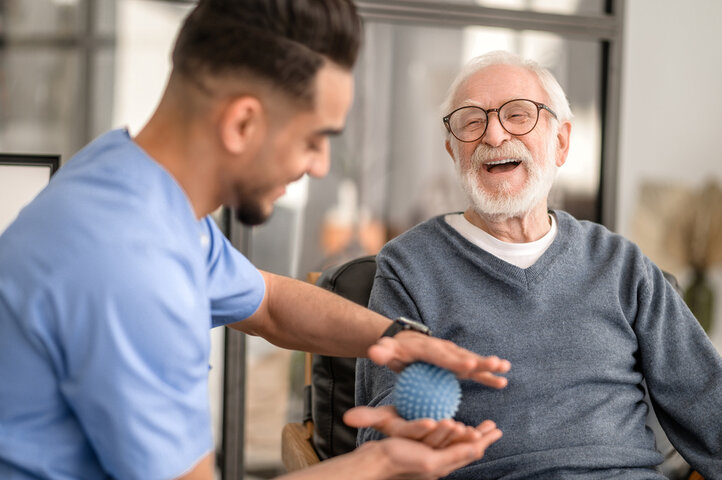 reisdent having his hand massaged with a spiky massage ball